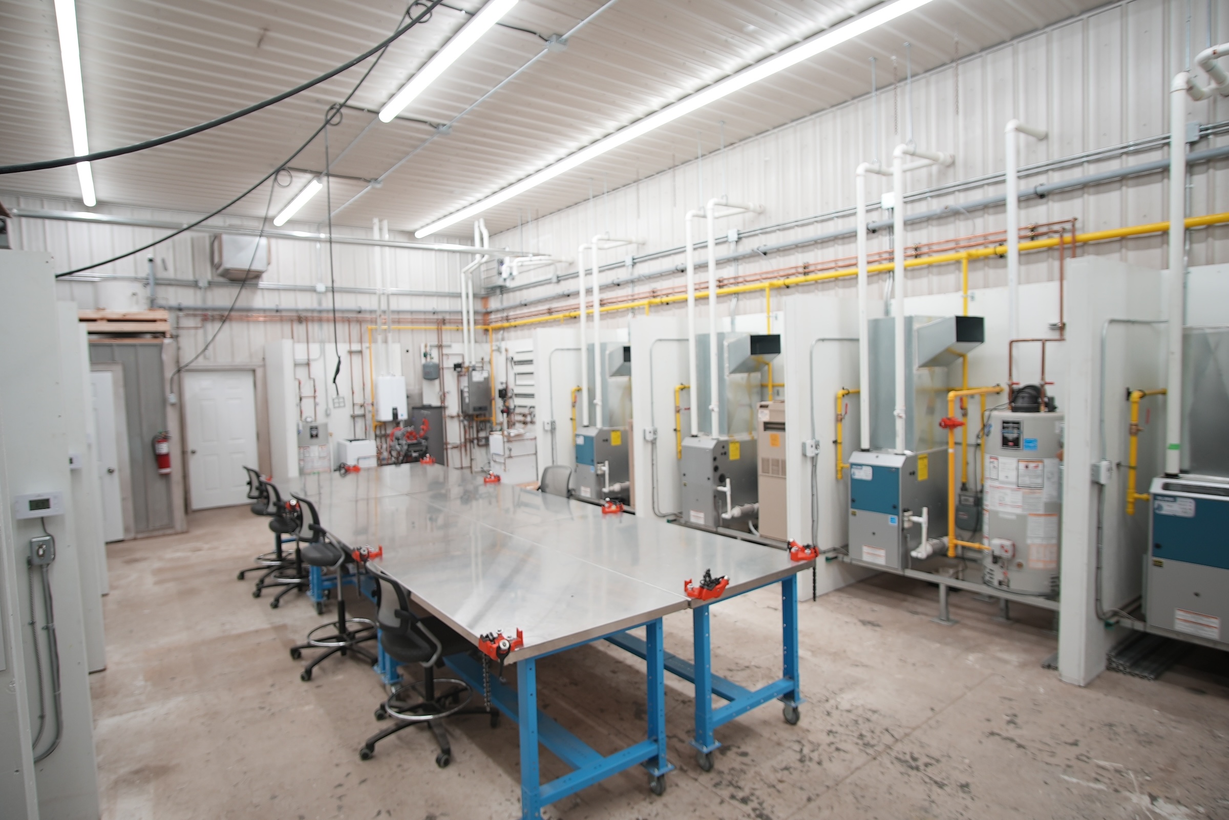 A lab at the Tyendinaga location contains a large metal work surface in the centre and HVAC equipment lined up along the side.