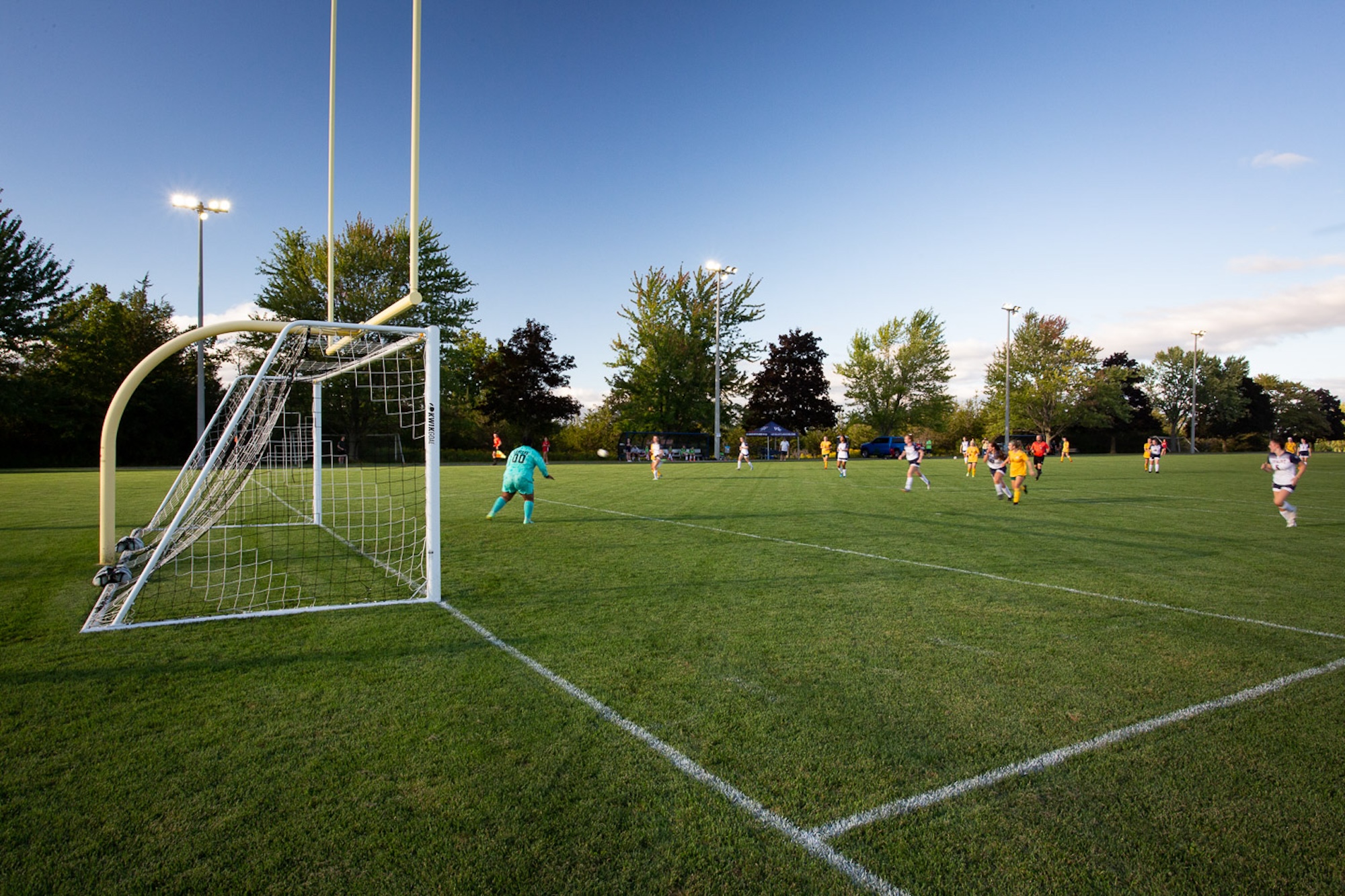 The soccer field is shown with the net on one side and students playing soccer on the other.