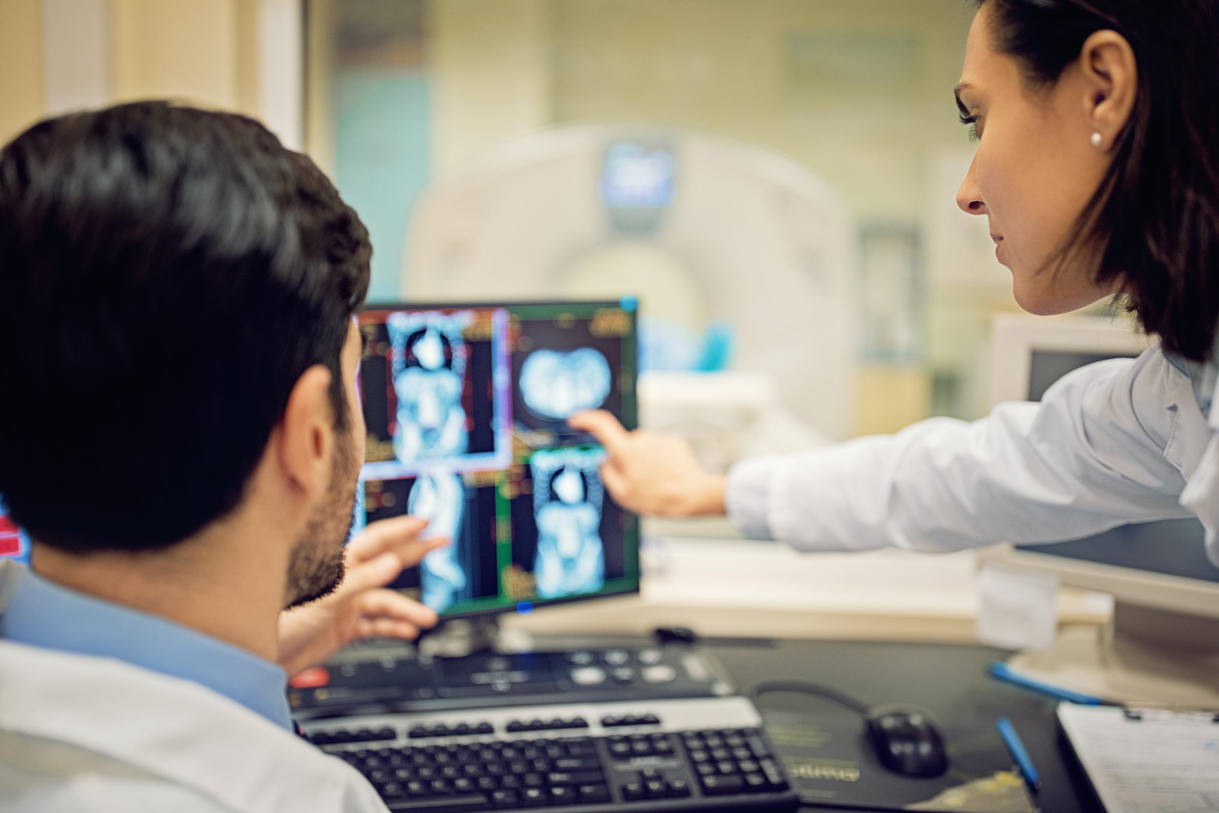 Two side profiles of two people are seen looking at a screen in the medical radiation technology program.