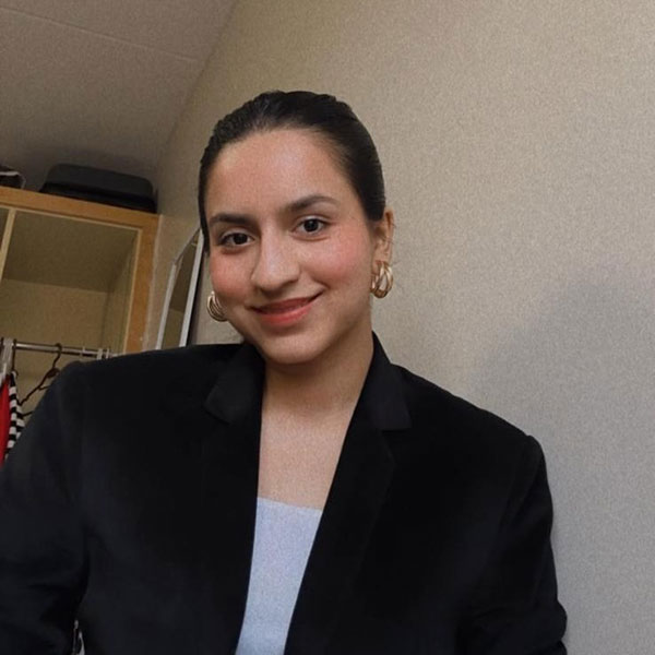 Maitri Narayan Kansara, biotechnology student, is sitting and smiling towards the camera.