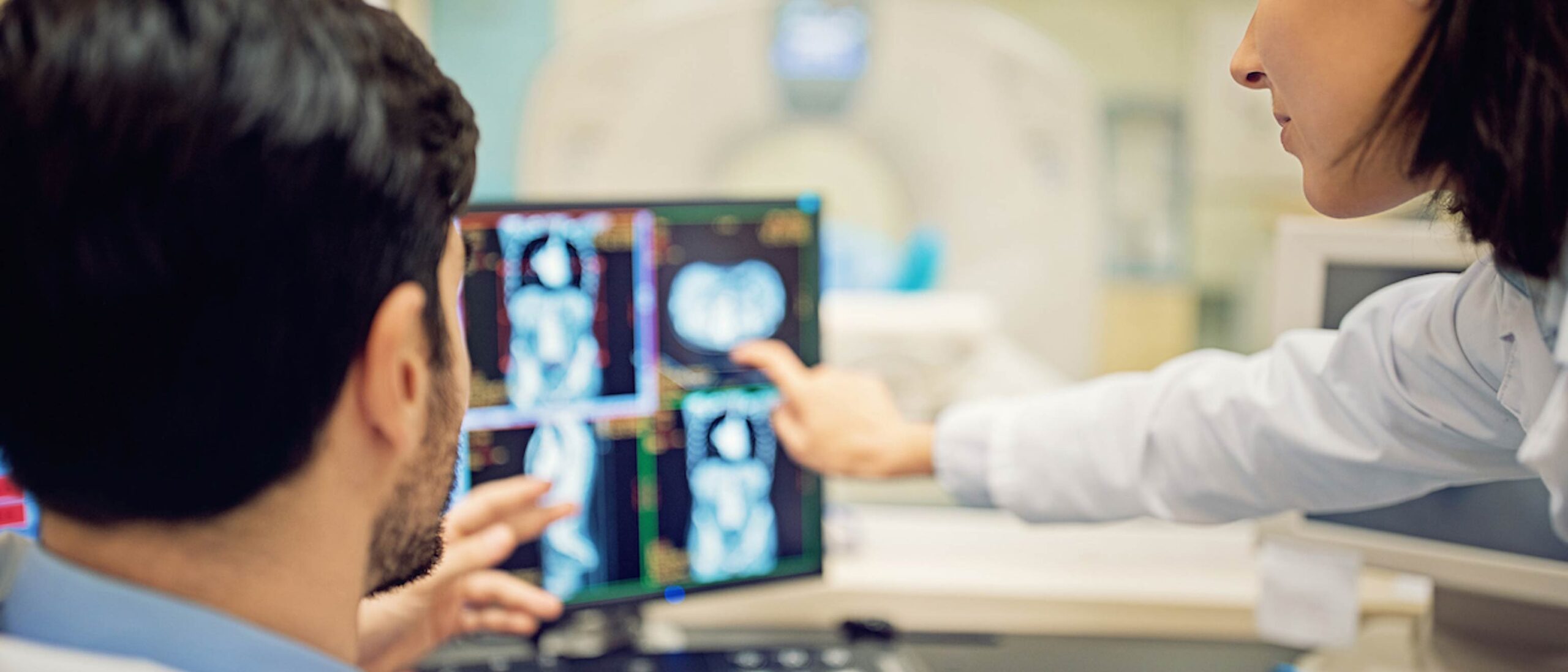 Two side profiles of two people are seen looking at a screen in the medical radiation technology program.