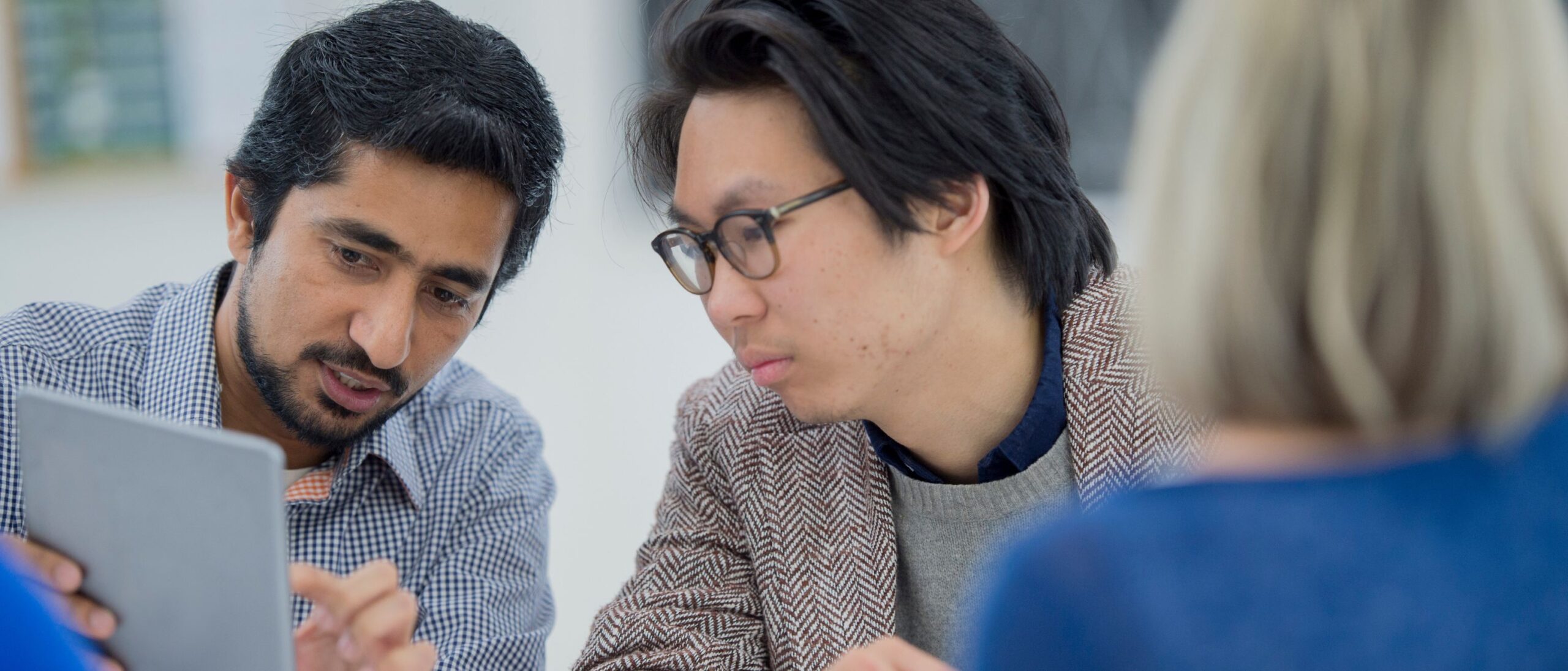 A group of project management students are sitting down and working together on a project.