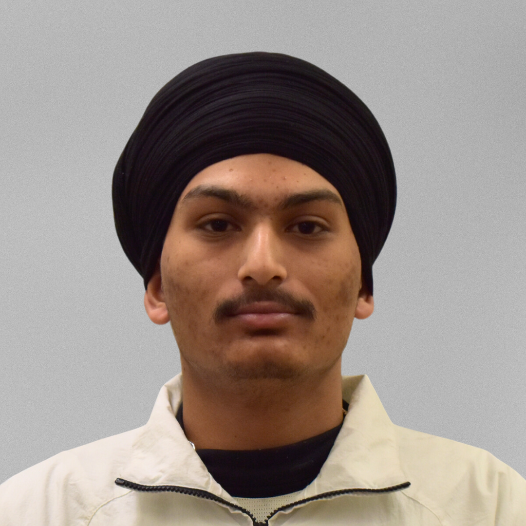 A headshot of Hardeep Singh in front of a grey background.