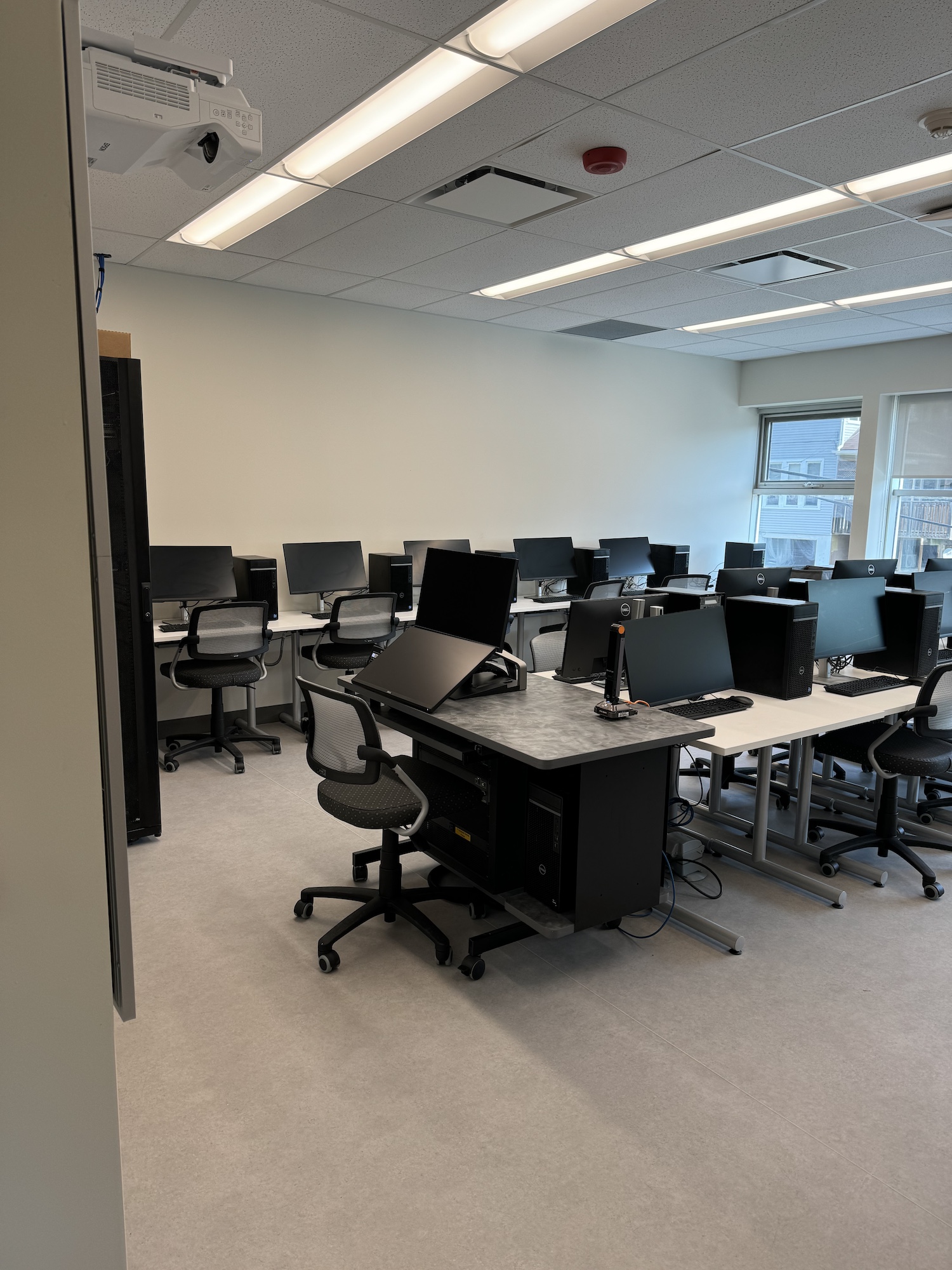 An empty classroom with computers at the desks at the Port Hope campus.