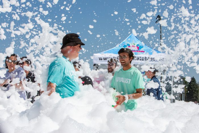 President and CEO Mark Kirkpatrick and a student standing in a large patch of foam.