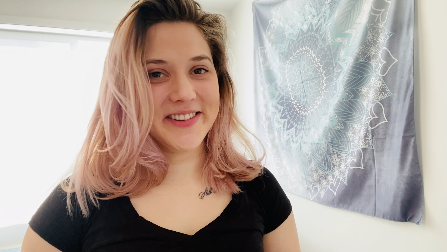 Headshot of Ashley Macdonald, a Paramedic student, smiling with a grey patterned tapestry on the wall behind her.