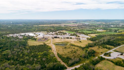 An aerial view of Loyalist College, showing buildings, the trails, and the city behind it.