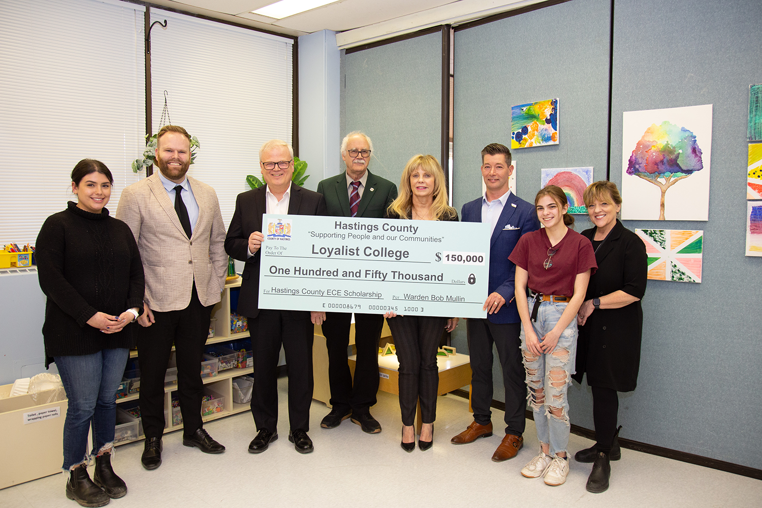 A group of people, including Loyalist President and CEO Mark Kirkpatrick, posing with a giant check showing a donation of $150,000 made to the college from the County of Hastings.