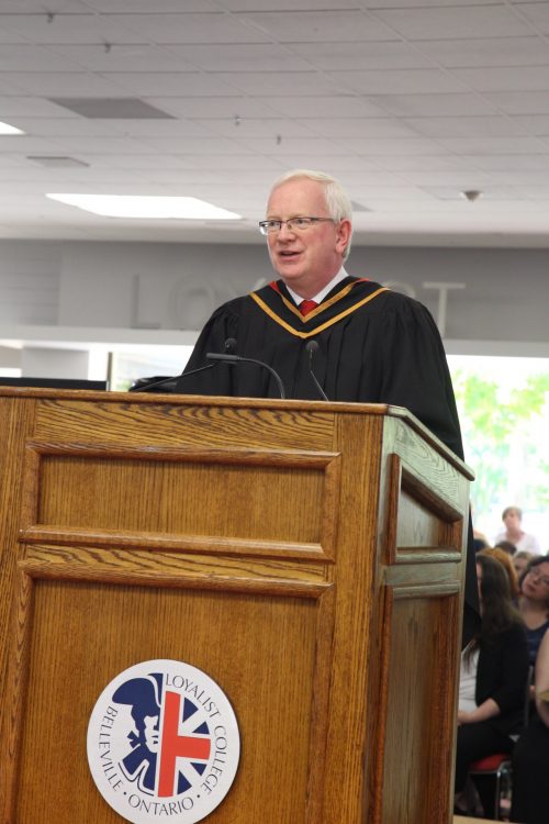 Professor Cunnane, President of Limerick Institute of Technology standing behind a podium, and a well lit open space is behind him.