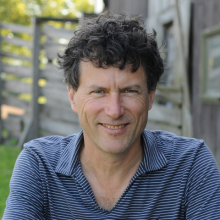 A headshot of Chef Jamie Kennedy, in front of a blurred outdoor background.