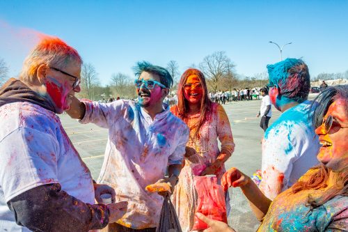 Four Loyalist students covered in powdered colours, spreading colour onto Loyalist President and CEO Mark Kirkpatrick.