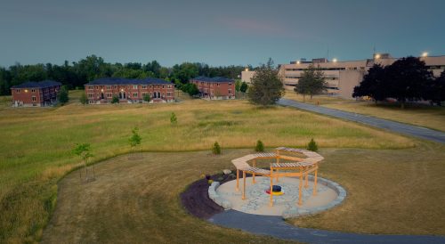 An aerial view of the A’nó:wara Learning Circle behind Loyalist College. In the background are residence buildings and part of the Kente building at the Belleville campus.