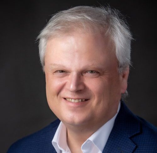 Headshot of Mark Kirkpatrick, newly appointed President and CEO of Loyalist College, in front of a black background.