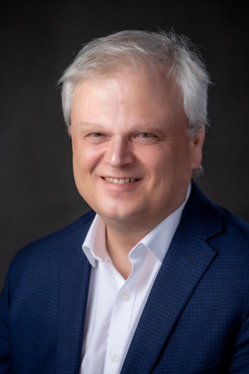 Headshot of Mark Kirkpatrick, newly appointed President and CEO of Loyalist College, in front of a black background.