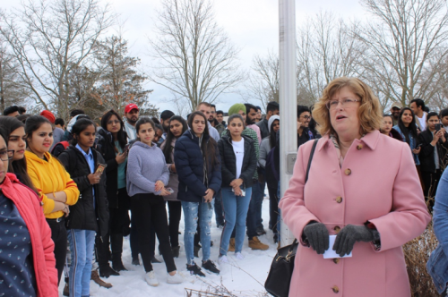 Dr. Ann Marie Vaughan, President and CEO, in a pink coat, speaking to a large group of gathered students, both pictured and not.