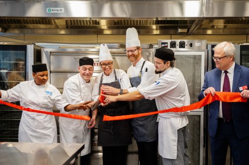 Three Culinary students, two professors and Loyalist President Mark Kirkpatrick in the new culinary lab, cutting a ribbon.