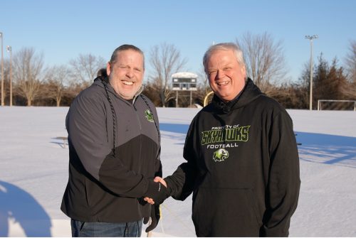 Mark Kirkpatrick, President and CEO of Loyalist, and Peter Gabriel, President of Skyhawks Football, shaking hands on the soccer field at Loyalist College.