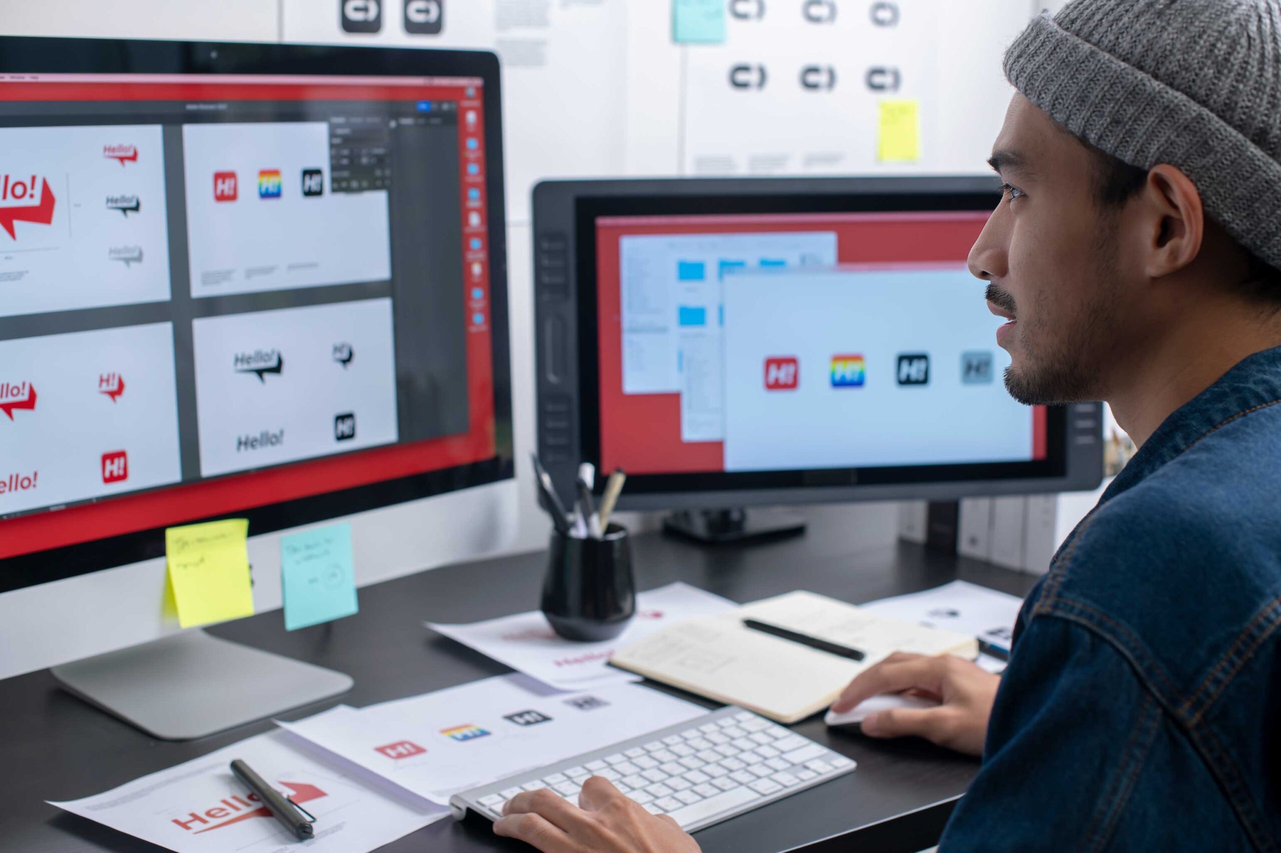 A student is sitting at a computer with different logo variations with a "hello" logos on the screen.