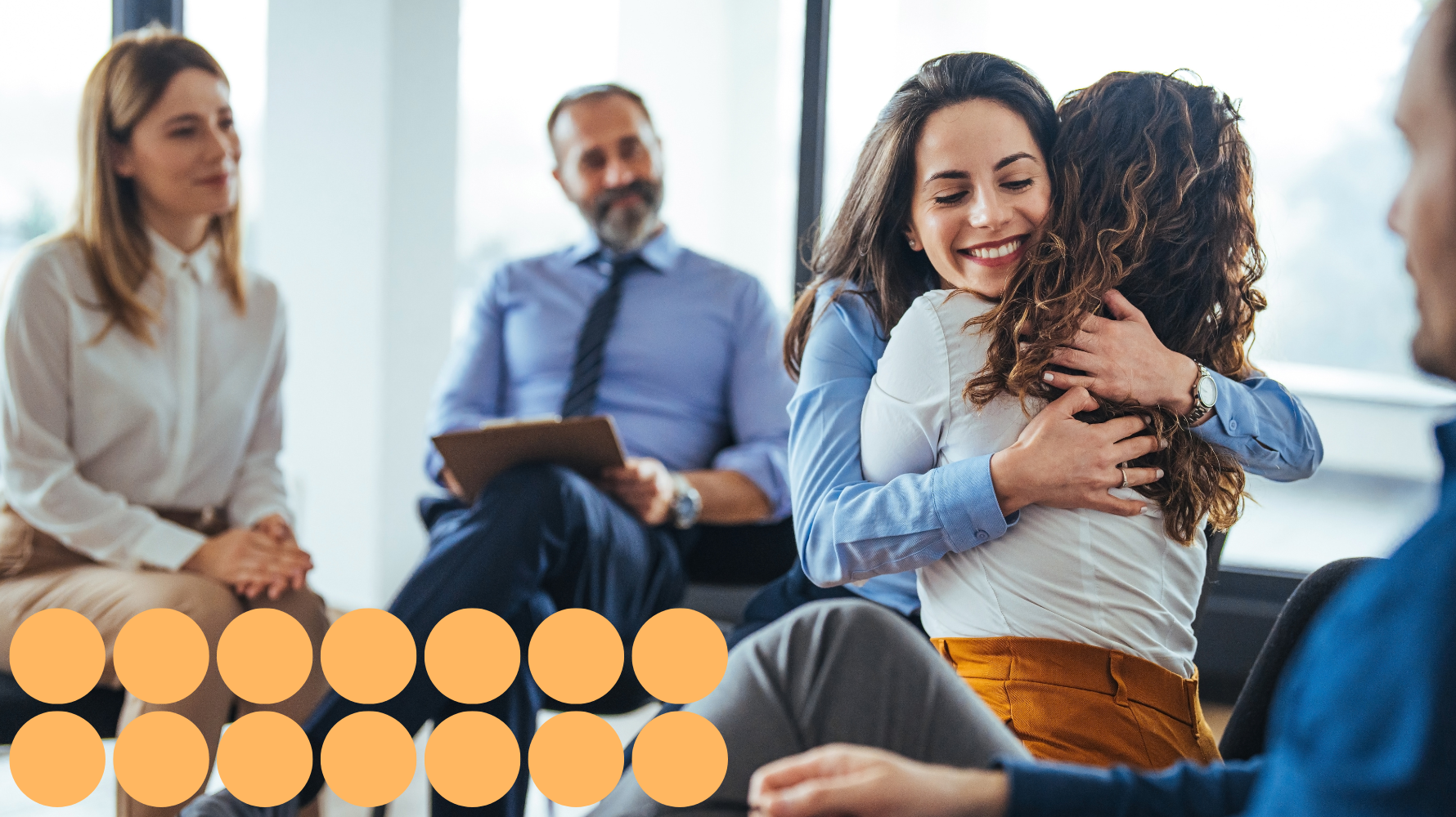 Two women hugging during a supportive group counselling session.