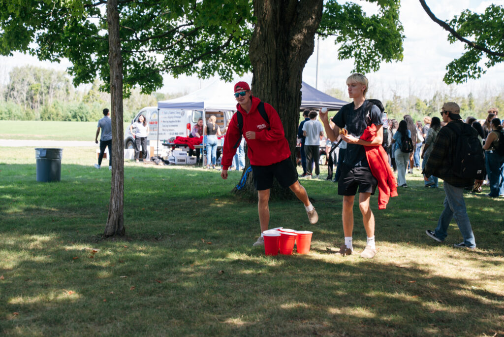 Two Loyalist College students work together to win an outdoor lawn game