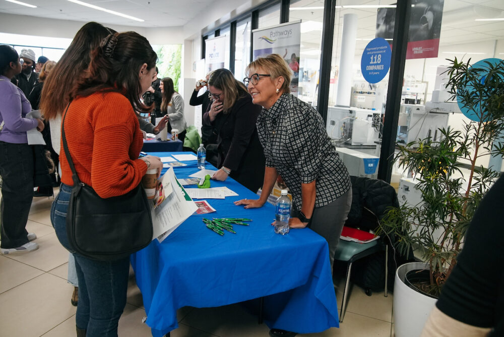 A student engages with an employer at a career fair.