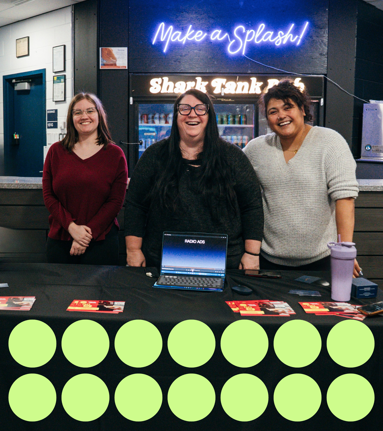 Group of people smiling behind a table at Open House.