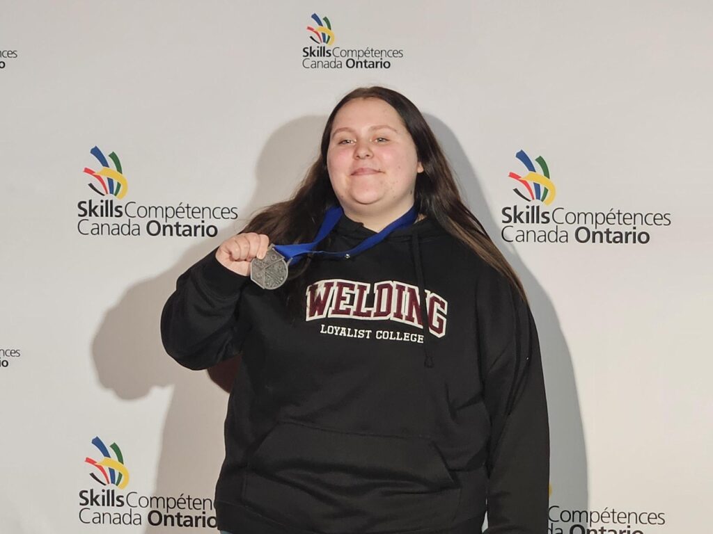 Loyalist College student Emily Desjardins smiles with her silver medal at the 2026 Skills Ontario Competition