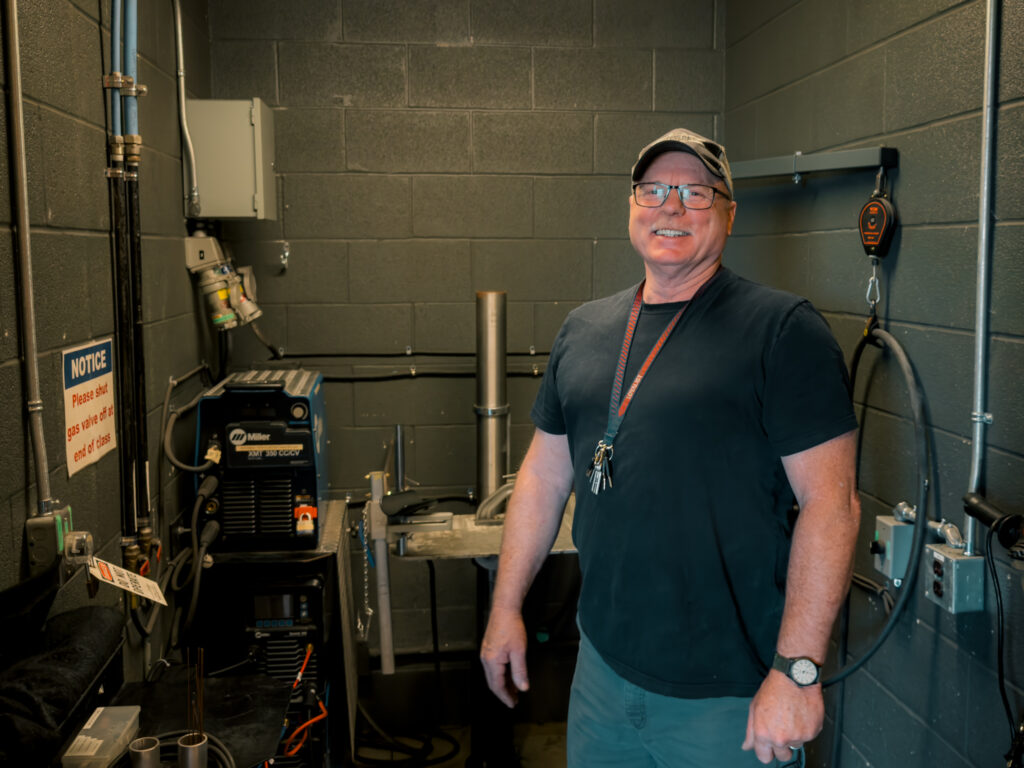 Technician Harold McQuigge stands in the accessible welding booth he designed in collaboration with a student at Loyalist College.