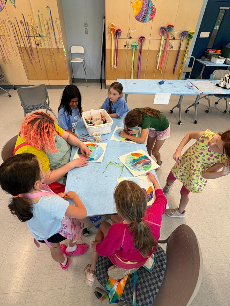 A facilitator works with a small group of children in a summer art class offered by the Loyalist College Arts Experience.