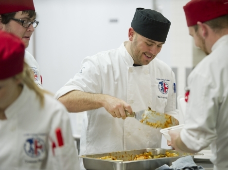 Culinary student Dave Stewart, centre, prepares lasagna at Club 213 during the fundraiser. 